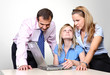 Three colleagues working at a computer.