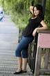 Smiling relaxed latin brunette girl outdoor full length portrait