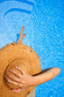 Mujer tomando el sol con sombrero de mimbre Mujer tomando el sol con sombrero de mimbre