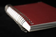 red spiral notebook isolated on black