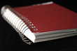 red spiral notebook isolated on black