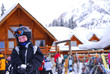 Young girl in ski gear holding a snowball at a skiing resort