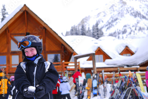Photo: Young girl in ski gear holding a snowball at a skiing resort Young girl in ski gear holding a snowball at a skiing resort