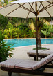 sun beds under umbrella at the poolside