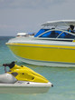 Yellow water scooter and speedboat at sea.