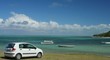 White small car on green grass by the beach White small car on green grass by the beach