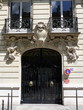 Porte cochère noire sur façade de pierre blanche, Paris