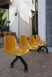 Orange chairs standing in the sun outside a shop