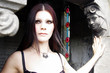 Amber eyed gothic woman inside stone mausoleum