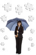 Young businesswoman with umbrella and puzzle pieces
