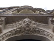 Sculpture en pierre, tête de femme souriante sur façade Paris
