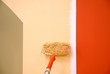 three colors painting a wall with a roll 