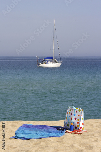 beach towel and bag with yacht in background