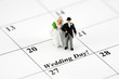 Miniature bride and groom on a calendar that says Wedding Day Miniature bride and groom on a calendar that says Wedding Day