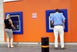 man and woman using cash machines/atm