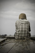 A poor man sitting at the helm of a boat deep in thought