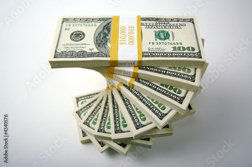 Photo: Spiraling Stacks of Hundred Dollar Bills on a white background. Spiraling Stacks of Hundred Dollar Bills on a white background.