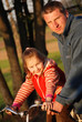 A father and daugther riding a bike outside A father and daugther riding a bike outside