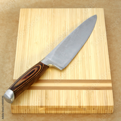 Large Knife on chopping board with brown background Large Knife on chopping board with brown background