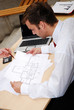 male architect working with blueprints