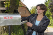 Foto: Frau leert Briefkasten Frau leert Briefkasten