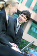 Business couple using laptop outdoors