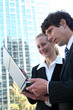 Business couple using laptop outdoors