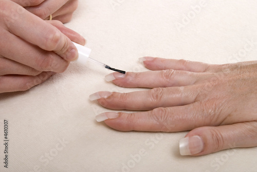 Photo: Applying clear nail varnish to acrylic finger nails Applying clear nail varnish to acrylic finger nails