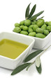 Fresh green olives and olive oil in square bowls