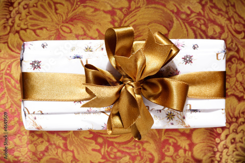 Photo: Gift box with a golden ribbon and bow. Gift box with a golden ribbon and bow.