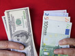 Older woman holds dollars and euros Older woman holds dollars and euros