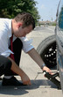 Photo: Businessman changing a tire Businessman changing a tire