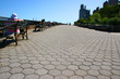 people relaxing on a boardwalk in front of buildings