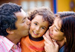 parents kissing son portrait