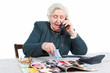 Grandmother is watching catalogue and making an order.