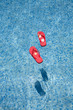 red flip-flops floating in a swimmingpool