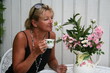 Swedish woman is taking a pause in garden with a cup of coffee