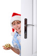 Boy with Santa's Hat peeking behind the door