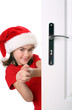 Girl with Santa's Hat peeking behind the door