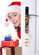 Girl with Santa's Hat peeking behind the door
