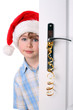 Boy with Santa's Hat peeking behind the door