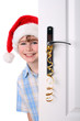 Boy with Santa's Hat peeking behind the door