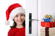 Girl with Santa's Hat peeking behind the door