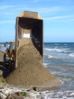 A truck off-loading sand on a spanish beach 