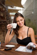 female sitting outside with a cup of coffee
