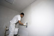 Junger Maler verspachtelt die Wand