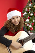 mädchen mit gitarre vor xmas tree