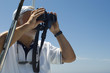 Captain of Racing Yacht Using Binoculars