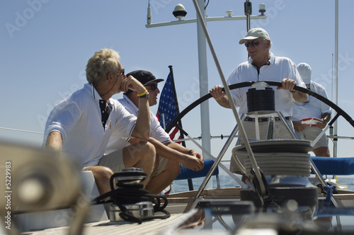 Photo: Crew at the Helm During Yacht Race Crew at the Helm During Yacht Race