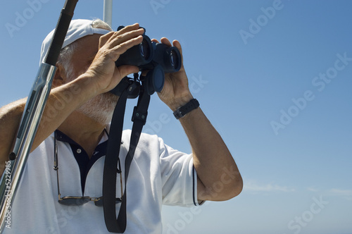 Photo: Captain of Racing Yacht Using Binoculars Captain of Racing Yacht Using Binoculars